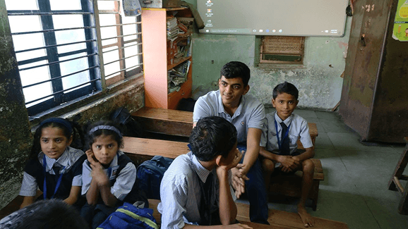 Raj with students in a classroom